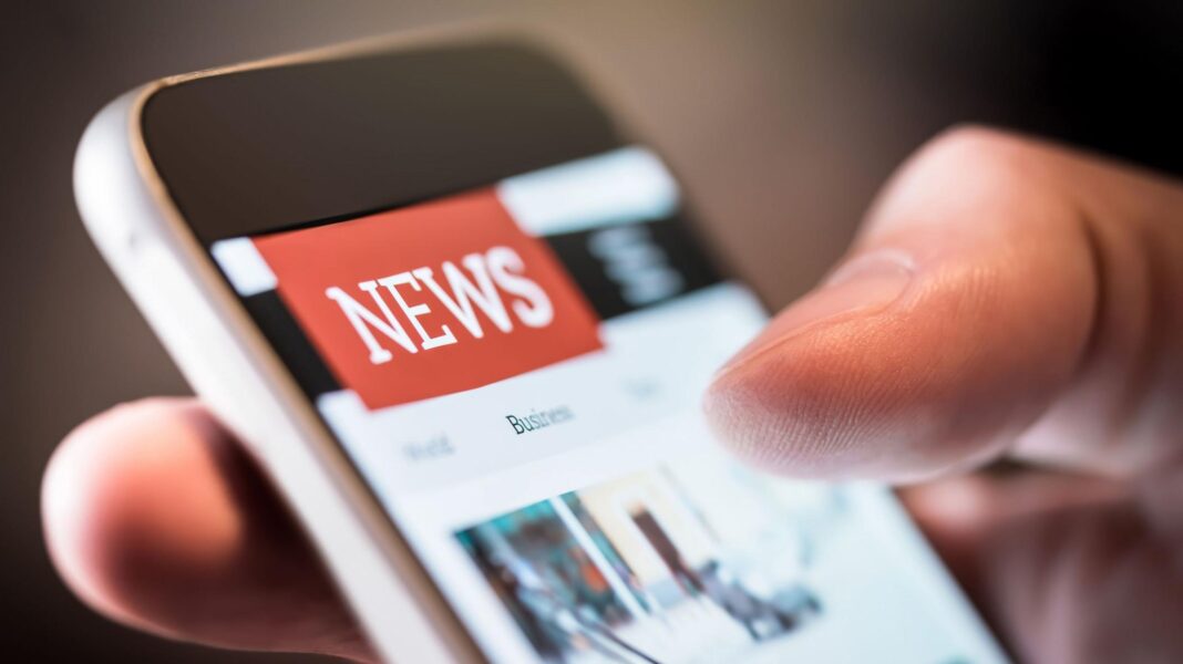 News media must stay relevant or ‘society will struggle’, says World News Day boss A close-up of a phone screen with a red "News" logo and someone's thumb and finger holding it