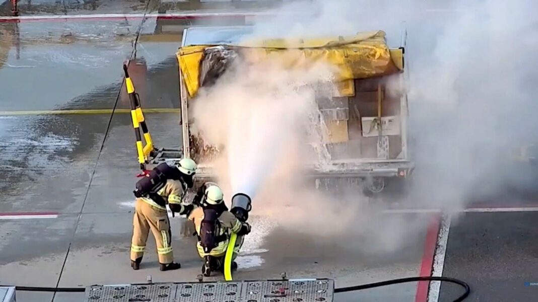 Europe targeted by spiralling campaign of sabotage and Russia is the chief suspect Two fire officers are spraying foam on an airport cargo trolley. Smoke is spreading from the trolly.