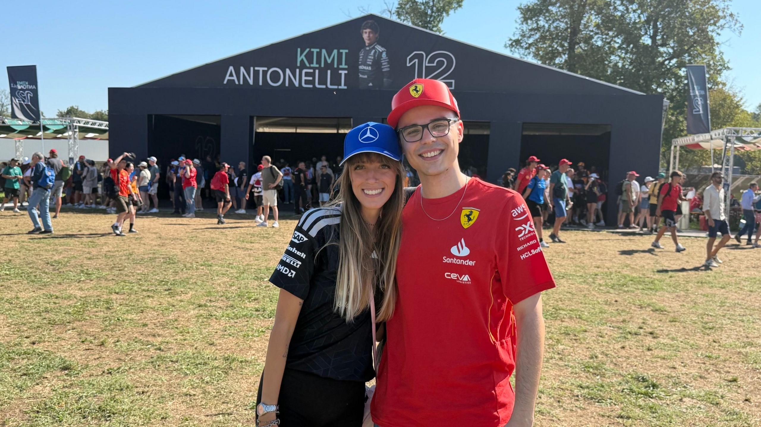 Emma, a Mercedes fan and Alessandro, a Ferrari supporter, pose for a photograph in front of the Kimi Antonelli stand at Monza