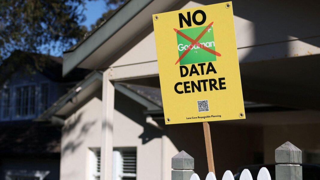 A yellow placard reading 'No data centre' in front of a house