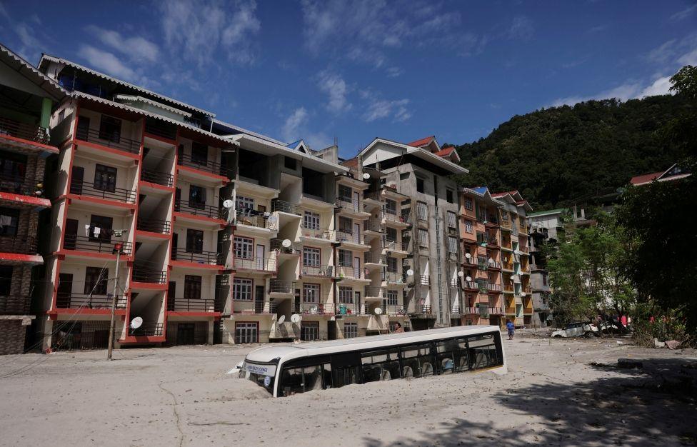 A bus is covered in debris caused by flash floods after a lake burst in Rangpo, Sikkim state, India, October 8, 2023. REUTERS/Francis Mascarenhas