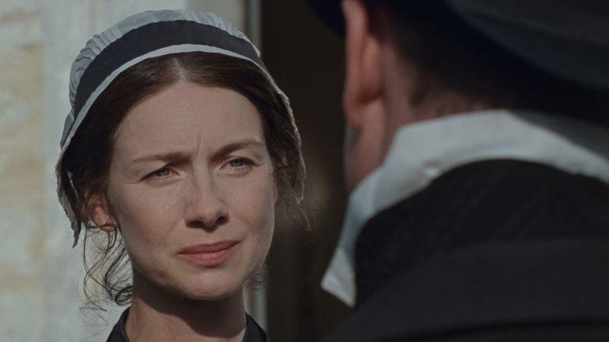 Actress Caitriona Balfe in a screen clip from the new adaptation of Sense and Sensibility and is wearing a black and white ladies' cap from the period
