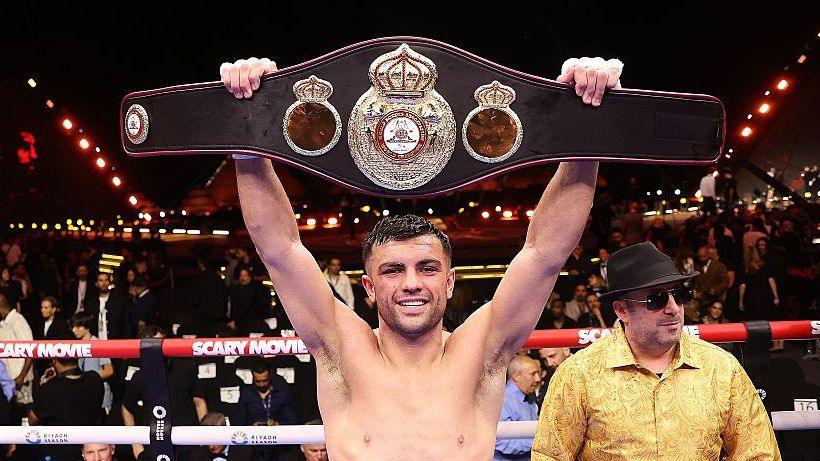 Jack Catterall holds a belt above his head in the ring