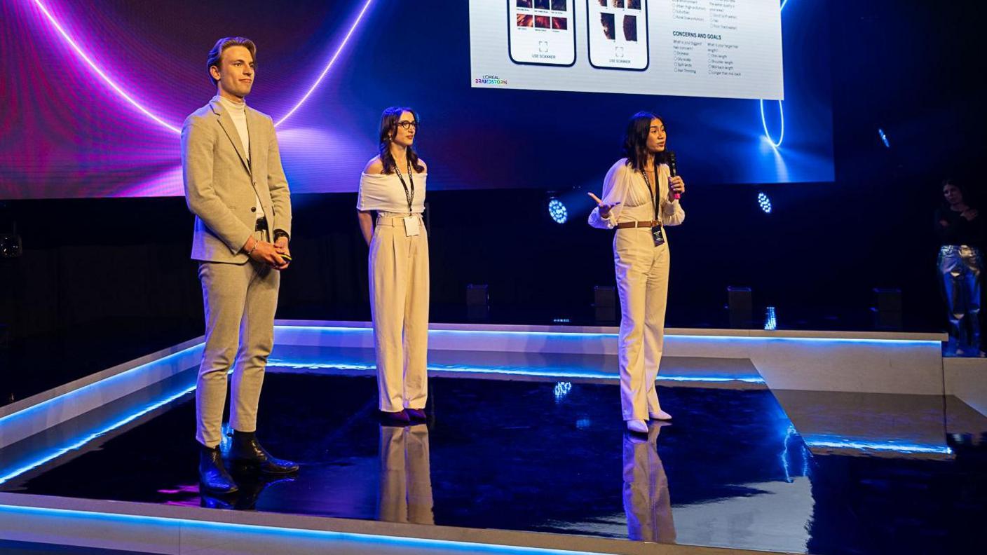 Yumi Liberman, centre, and her two friends up on stage at the UK final of L'Oréal's Brandstorm competition