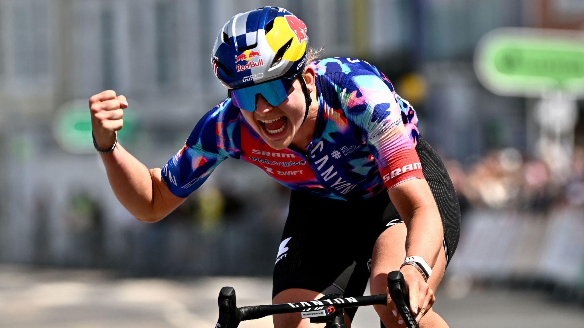 Zoe Backstedt clenches her fist in celebration as she rides across the line