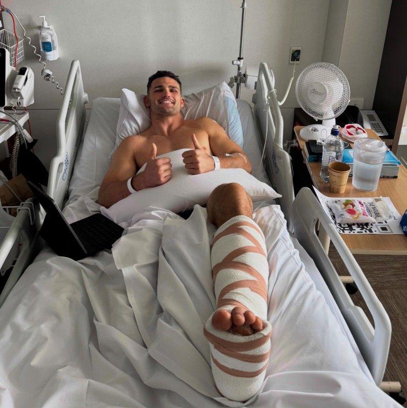 Nathan Cleary lies in hospital, giving a thumbs up
