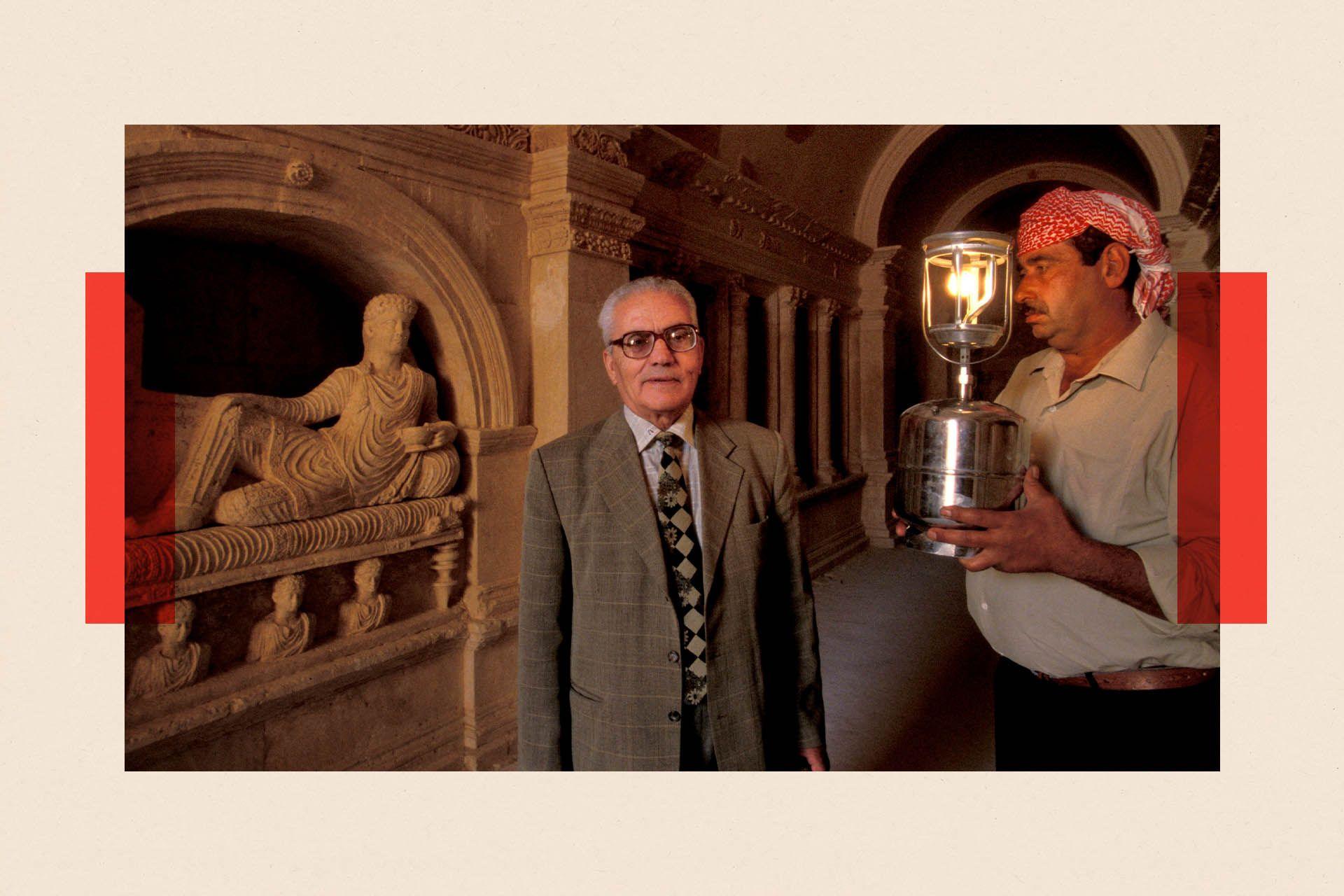 Khaled al-Asaad on the left, next to a sculpture of a reclining figure. A man holding a lamp stands to the right.