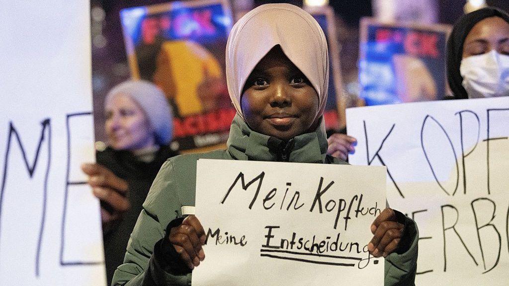 Hadiya, an 11-year old student, attends a protest, organized by coalition of 20 civil society organizations in Austria, against the headscarf ban in schools, in Vienna, Austria on February 13, 2026. She is holding a banner which says "my headscarf, my decision"