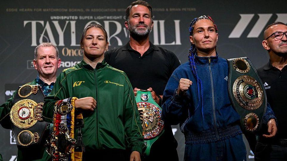 Katie Taylor and Flora Pili are flanked by Brian Peters and Eddie Hearn holding the light-welterweight world titles