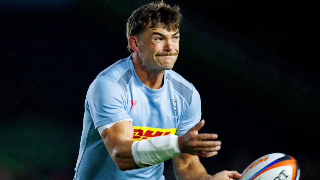 George Furbank, wearing a sky blue Harlequins shirt, throws a rugby ball during a game against Edinburgh