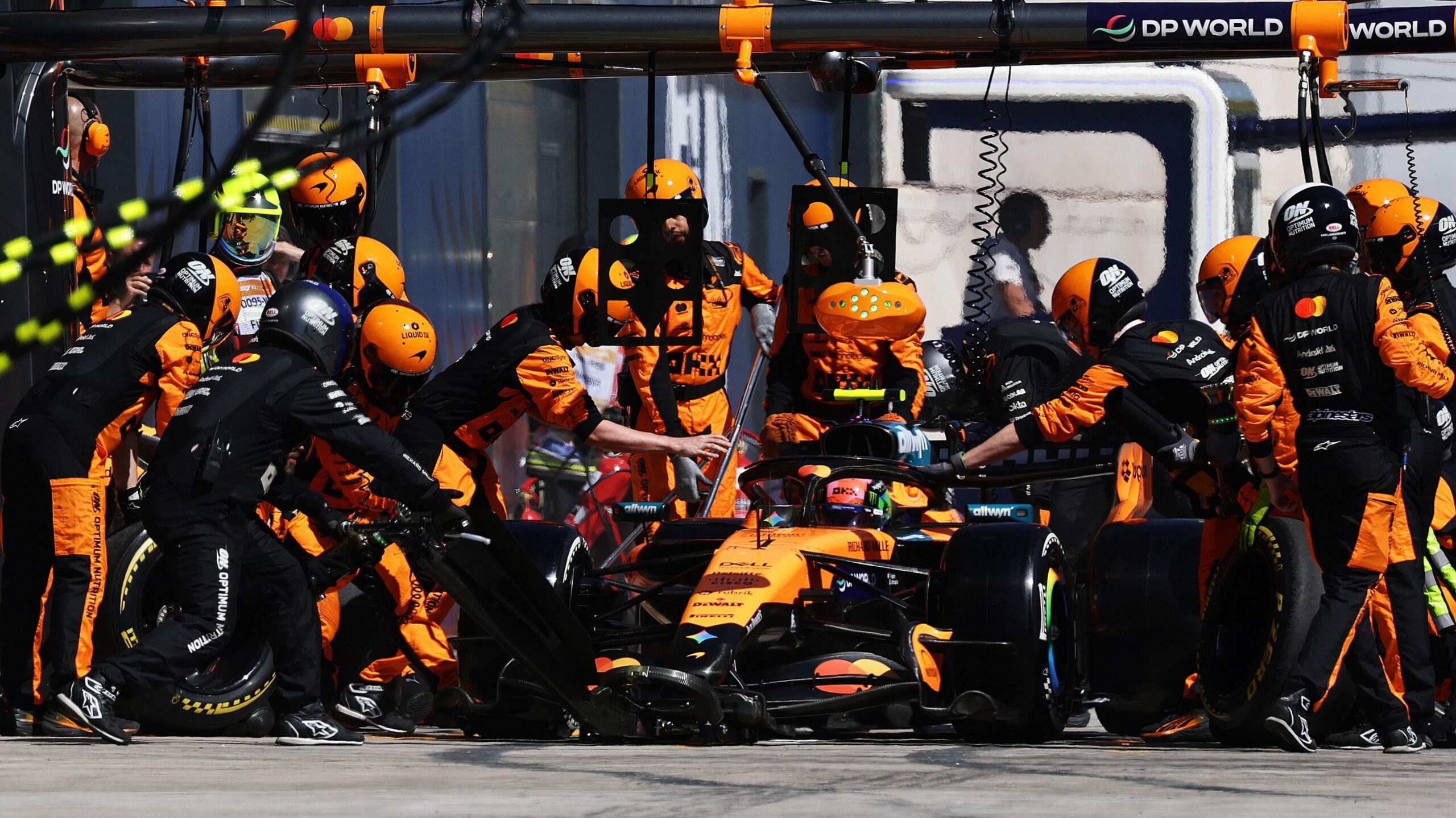 Lando Norris in the pit lane being serviced by McLaren mechanics during the Spanish Grand Prix
