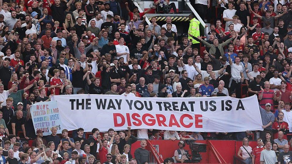 Manchester United fans unfurl a banner inside Old Trafford