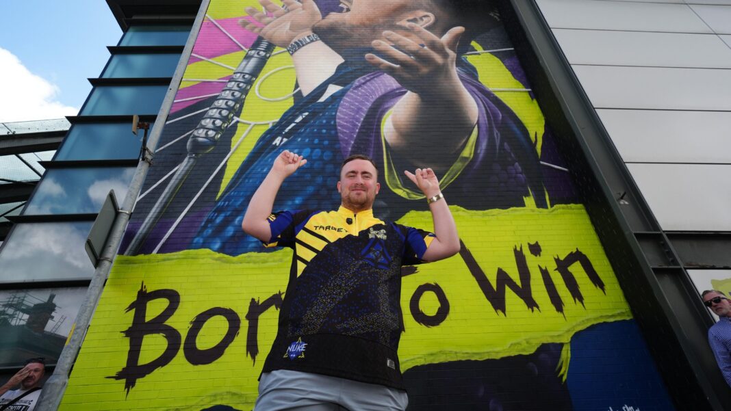 Luke Littler posing in front of his mural