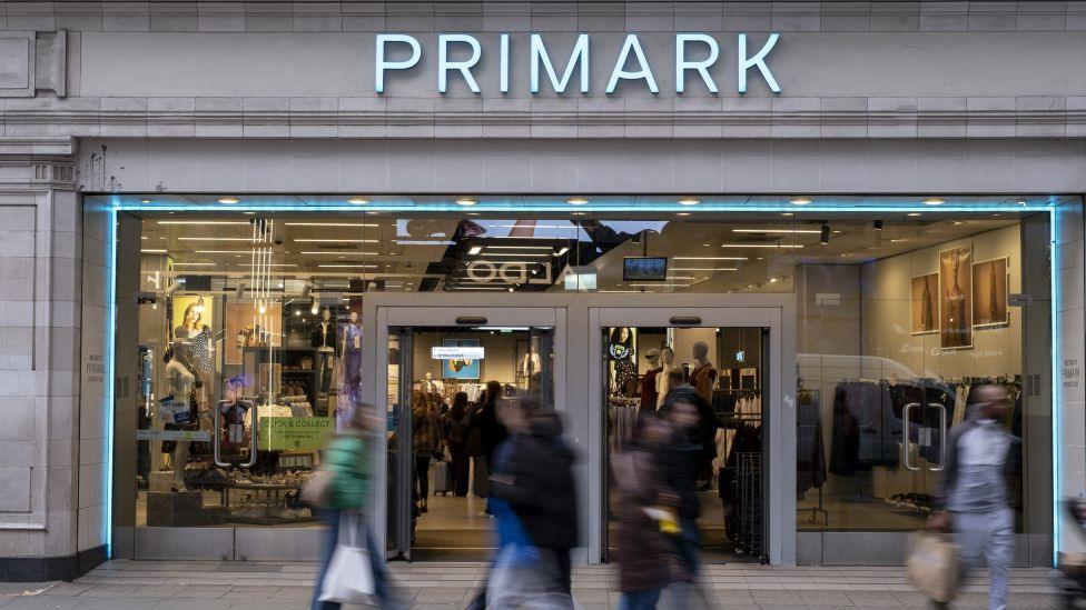 Shoppers, not in focus, walk past a Primark store in London