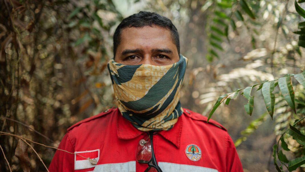 More than 170,000 respiratory cases recorded in haze-choked Indonesia A man in red firefighting uniform patched with Indonesia's flag, and with a yellow and green neck gaiter pulled over his face, stands in a forest and looks into the camera