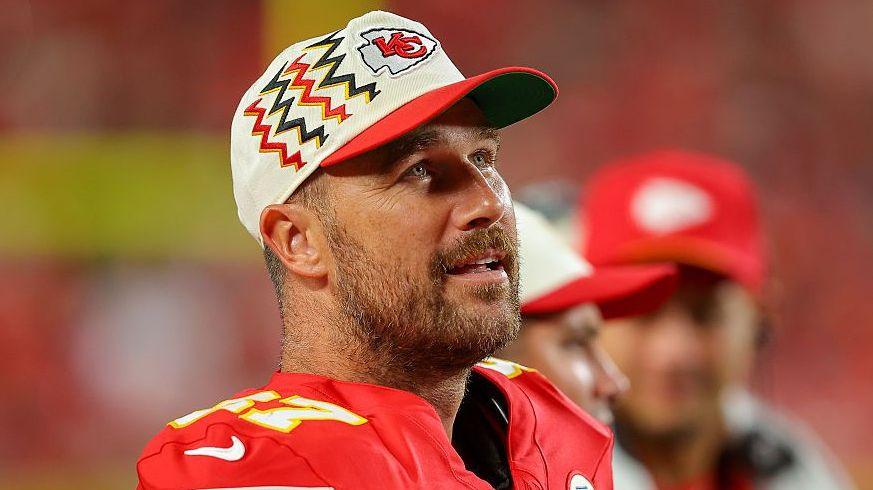 Travis Kelce stands on the sideline during a pre-season NFL game in 2026