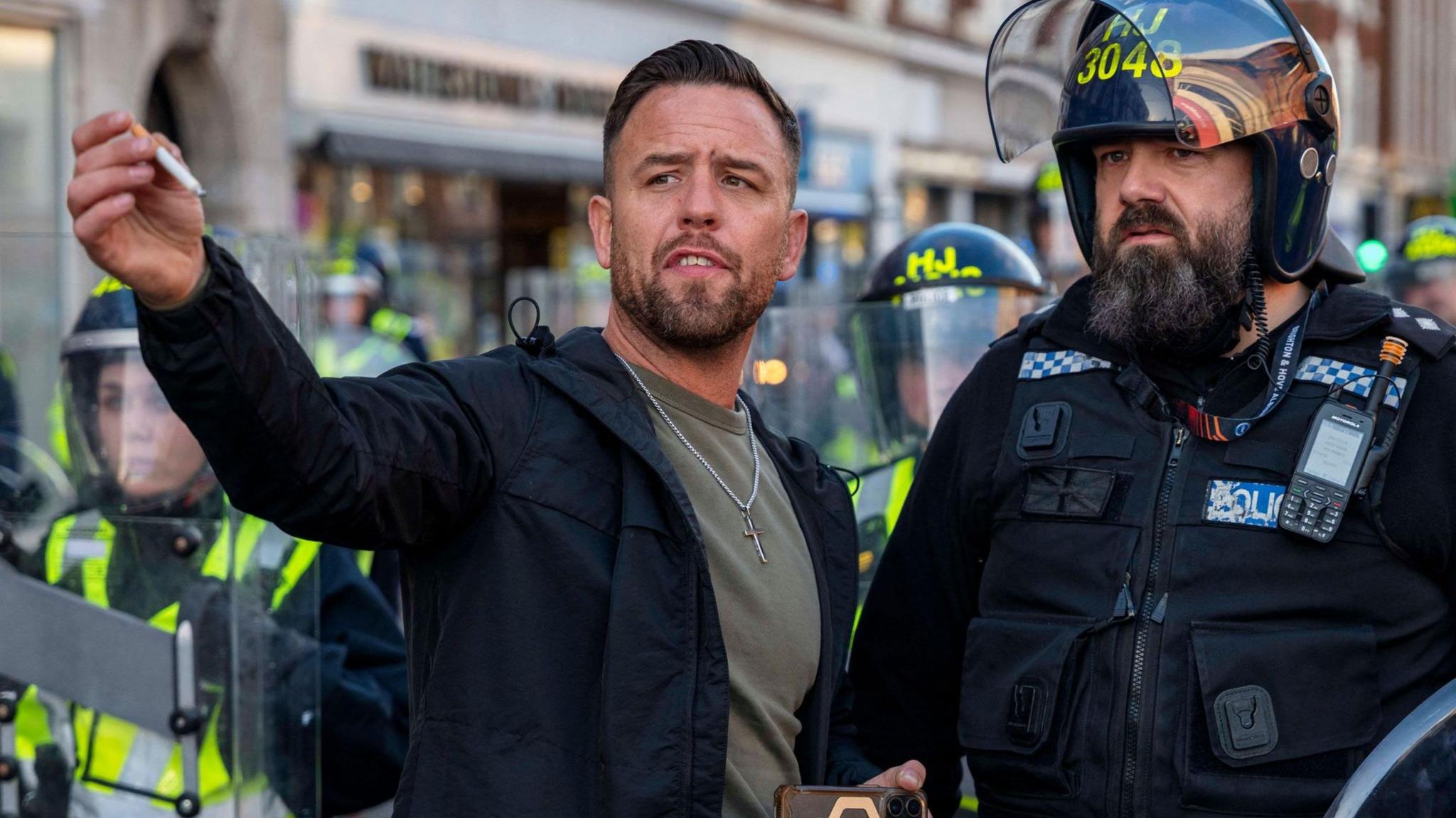A man talking to a police officer.