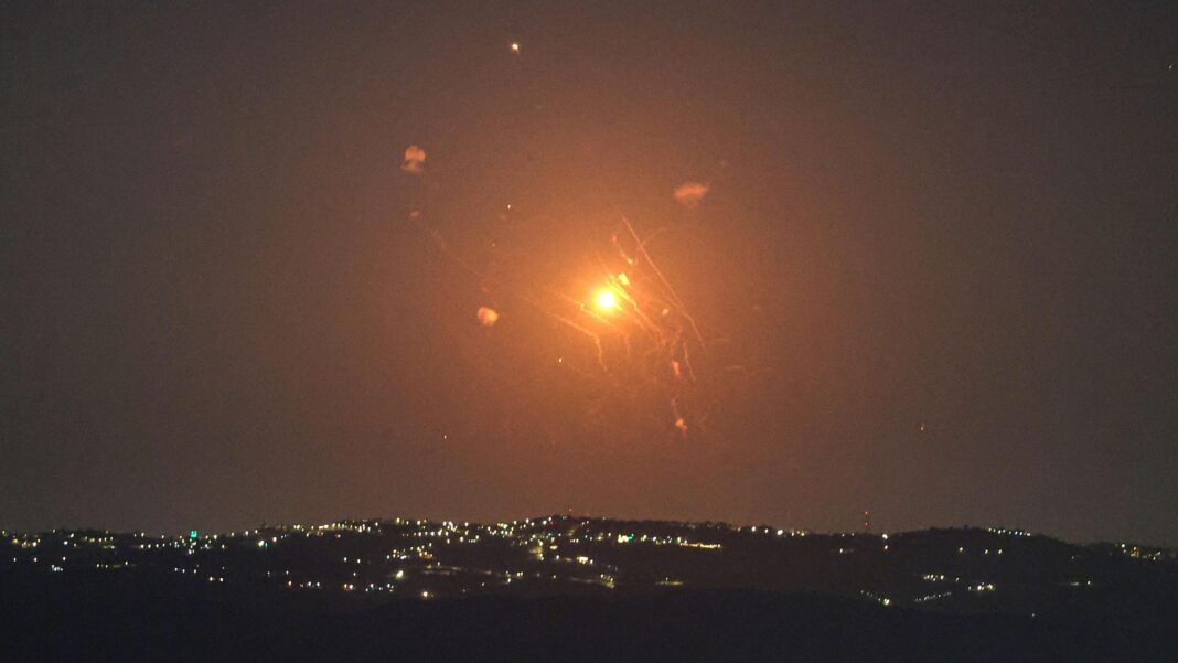 A red and orange missile being intercepted by Jordanian air defences in the sky as seen from the Israeli side of the Jordan Valley.