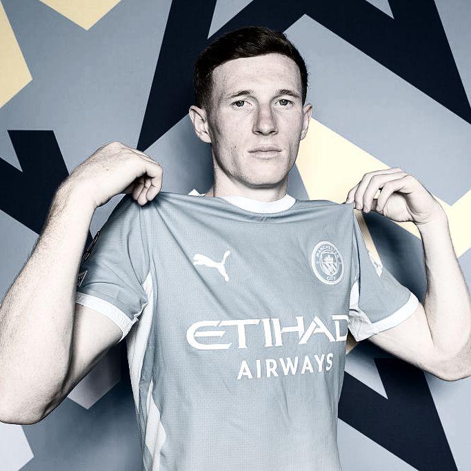 Elliott Anderson in his Manchester City shirt in a posed promotional picture