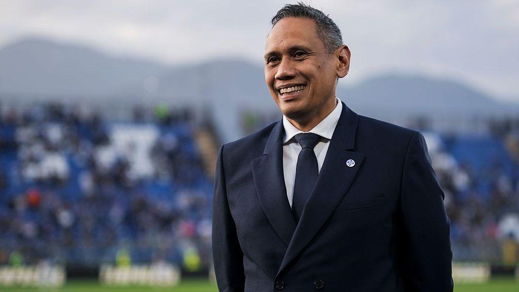 Como president Mirwan Suwarso, wearing a navy blue suit, white shirt and blue tie, smiles on the pitch before the Serie A match against Internazionale