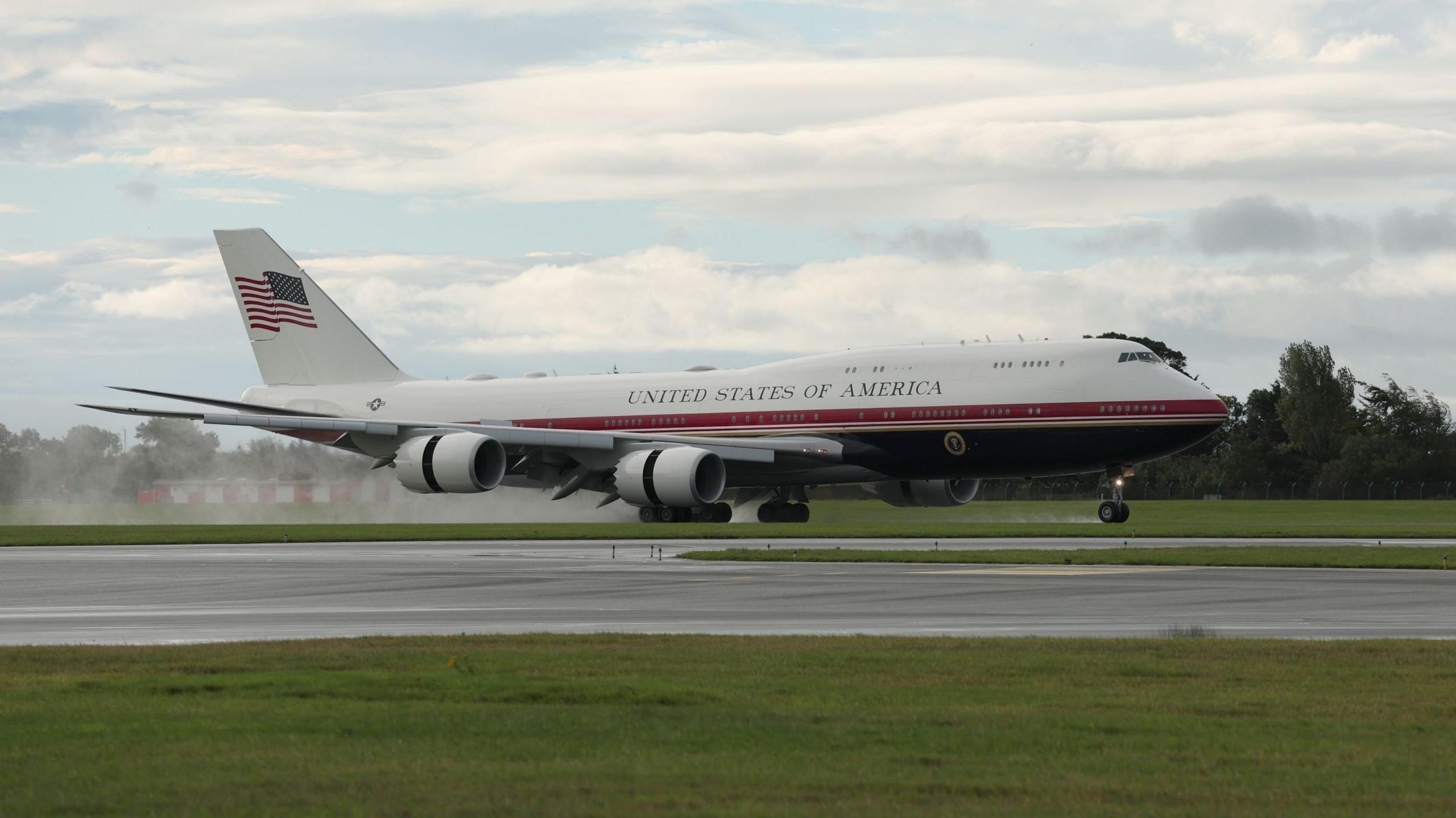Red, blue and white plane landing on tarmac