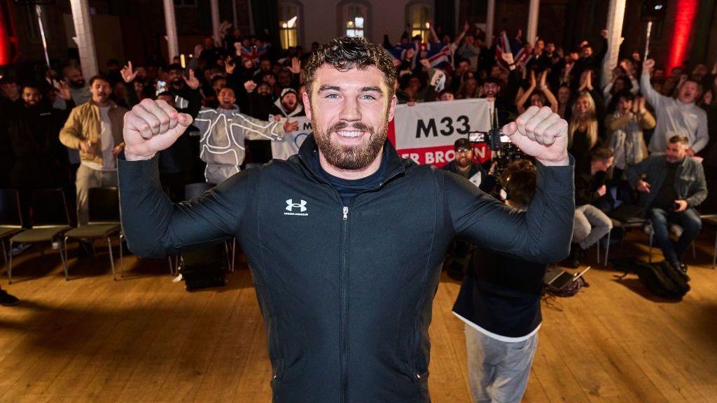 Pat Brown smiling with fans in the background
