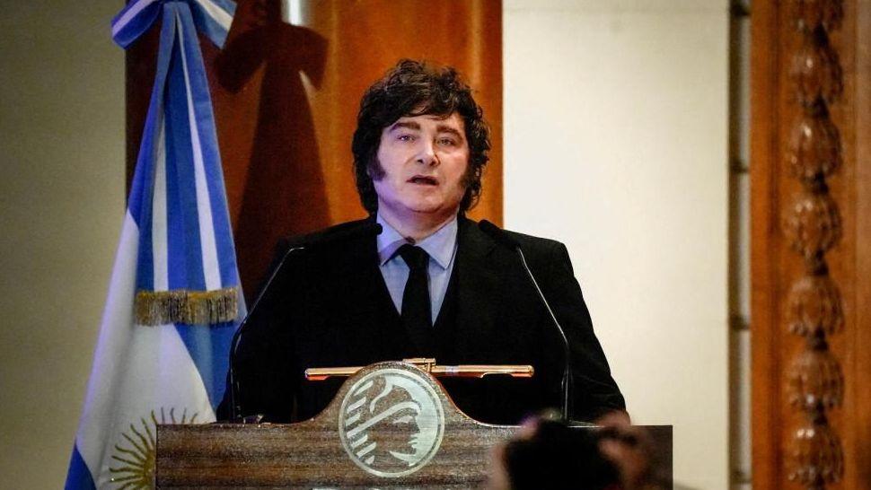 Argentine President speaks during a ceremony commemorating the 172nd anniversary of the Buenos Aires Stock Exchange in Buenos Aires, Argentina, July 16, 2026. He is wearing a dark suit with a black tie and a light blue shirt. He stands at a lectern and to his left there is an Argentine flag.