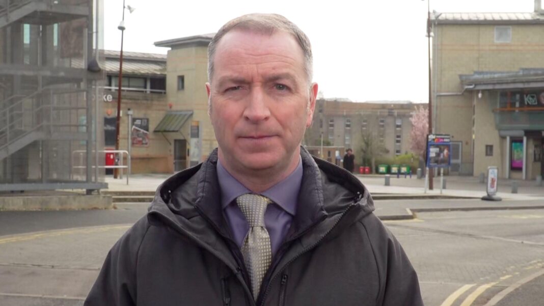 Scientists discover why Kent meningitis outbreak was so severe A man wearing a purple shirt and a silver tie looking towards the camera