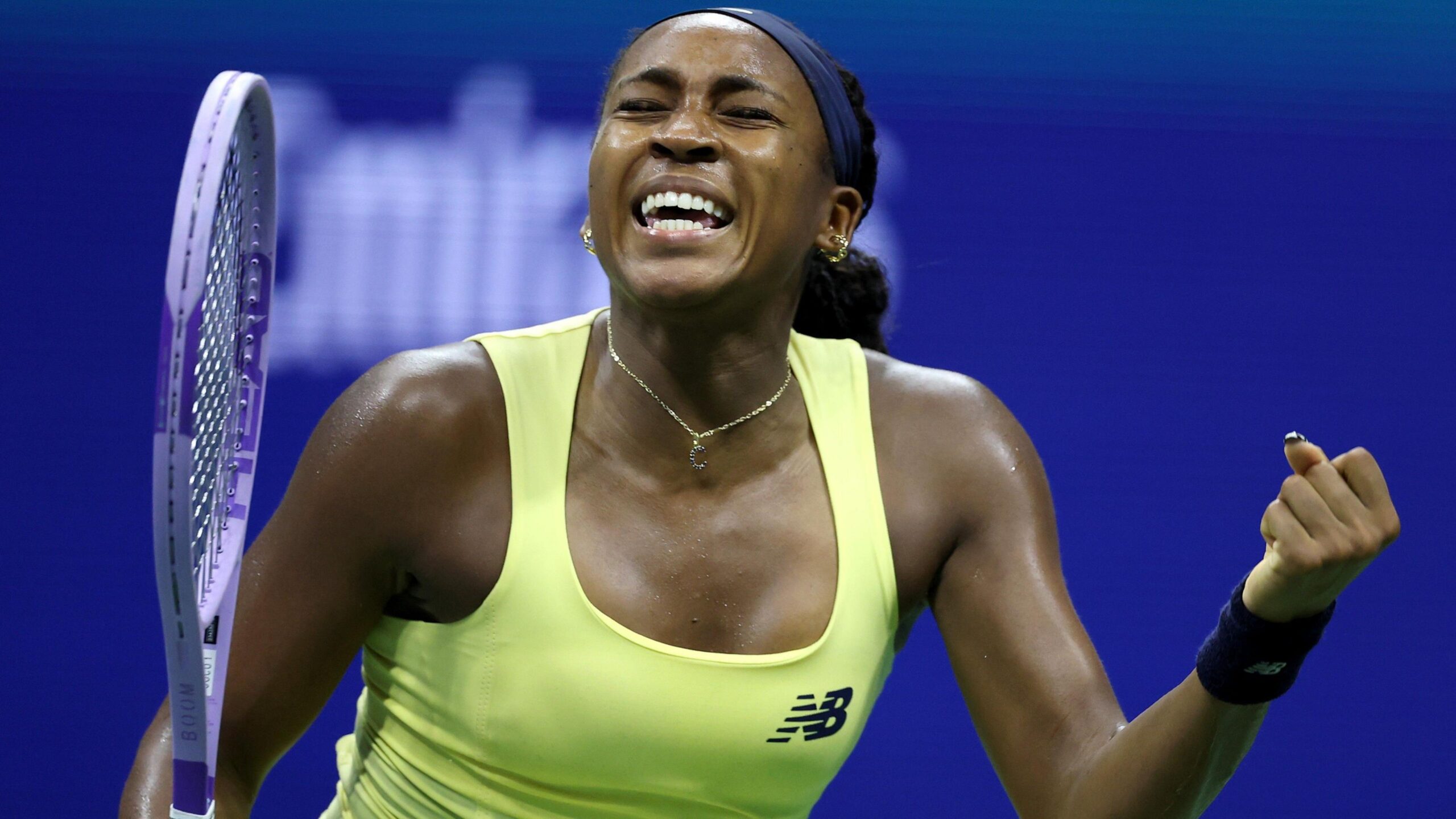 Coco Gauff clenches her fist and yells in celebration after beating Paula Badosa at the US Open