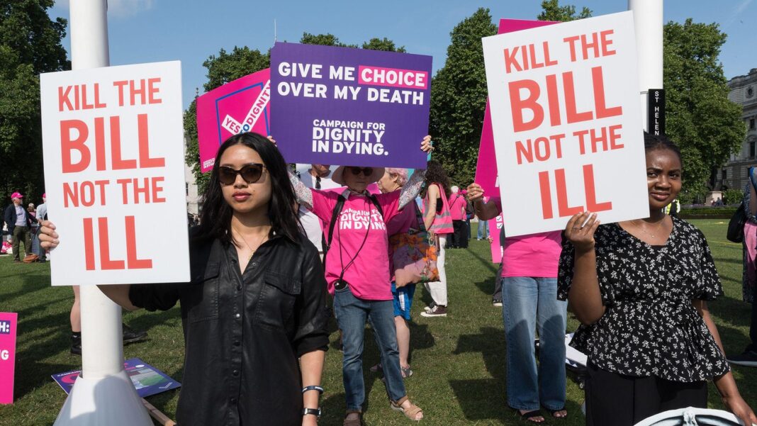 Why are MPs voting on assisted dying again? People holding signs saying 'kill the bill not the ill' and 'give me choice over my death' stand protesting outdoors in Parliament Square in early June 2025.