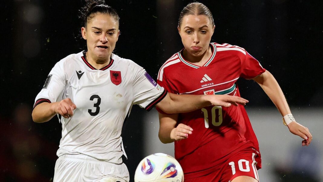 Albania's Arbenita Curraj in white competes for the ball with Wales' Mared Griffiths in red