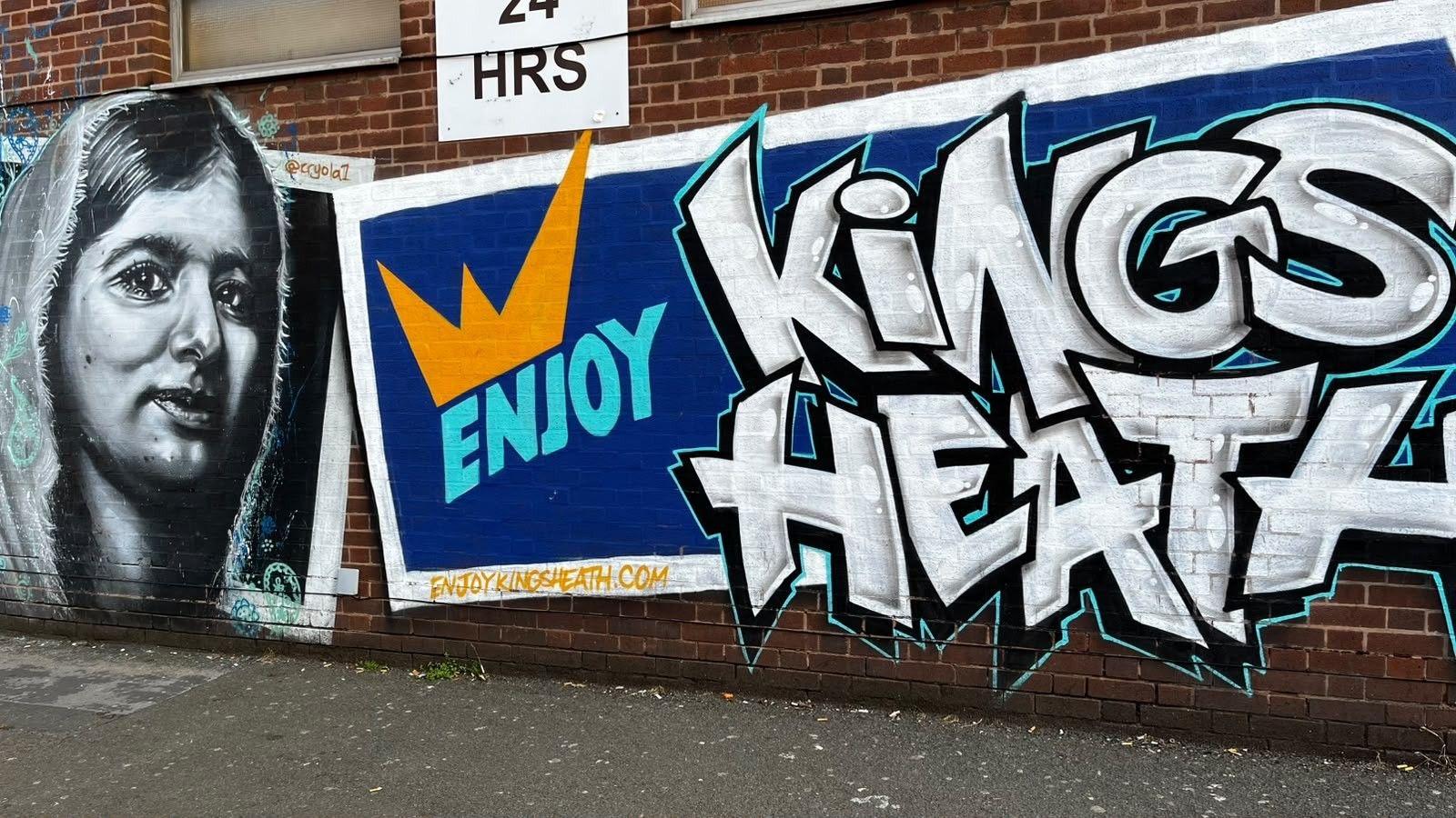 Image shows graffiti on a wall - on the left is a painting of Malala Yousafzai, the Pakistani education activist. It is a black, white and grey image of a young woman with a headscarf. On the right are the words Enjoy Kings Heath in large black and white letters