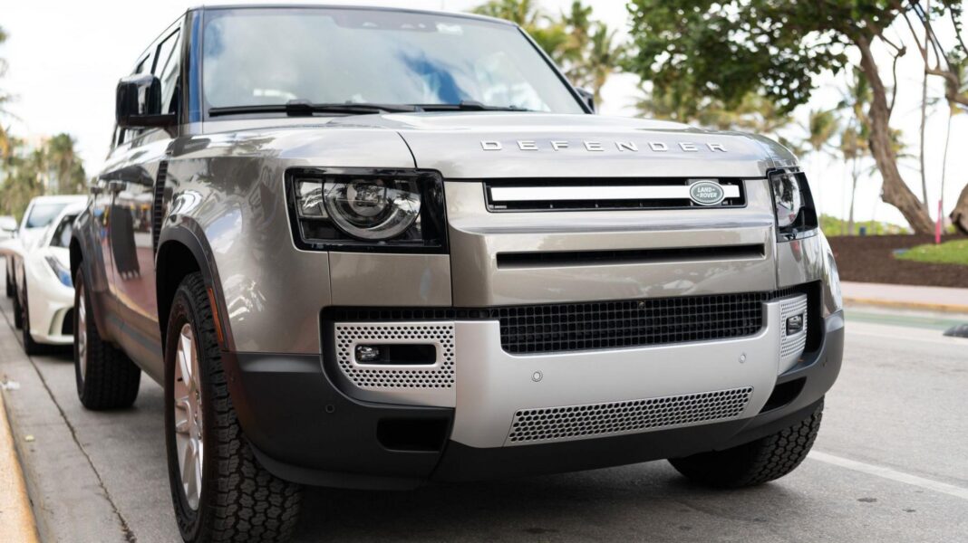 A silver Land Rover Defender parked on a road