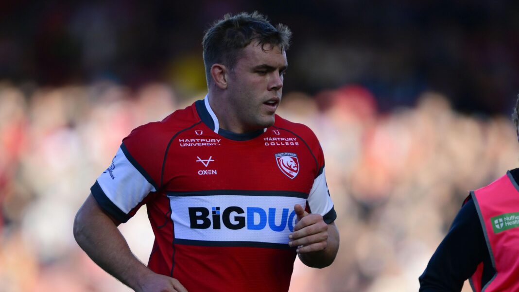 Singleton hopes for return after heart attack Jack Singleton jogging on the pitch during a match, he is wearing red Gloucester rugby kit