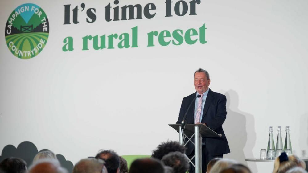 Lord Blunkett speaks against a white background.