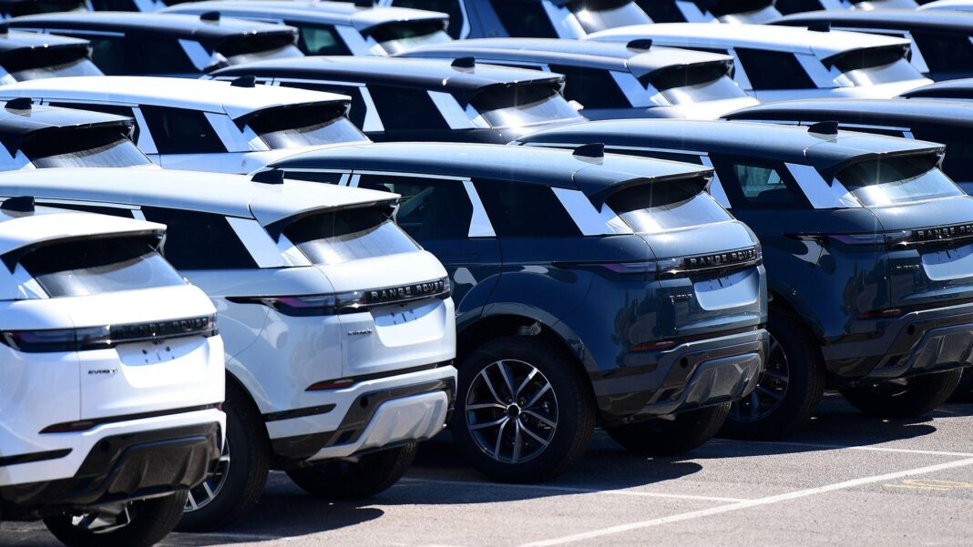 A photo taken in Halewood in 2025 shows rows of Range Rovers on the tarmac at a JLR factory outside on a sunny day.