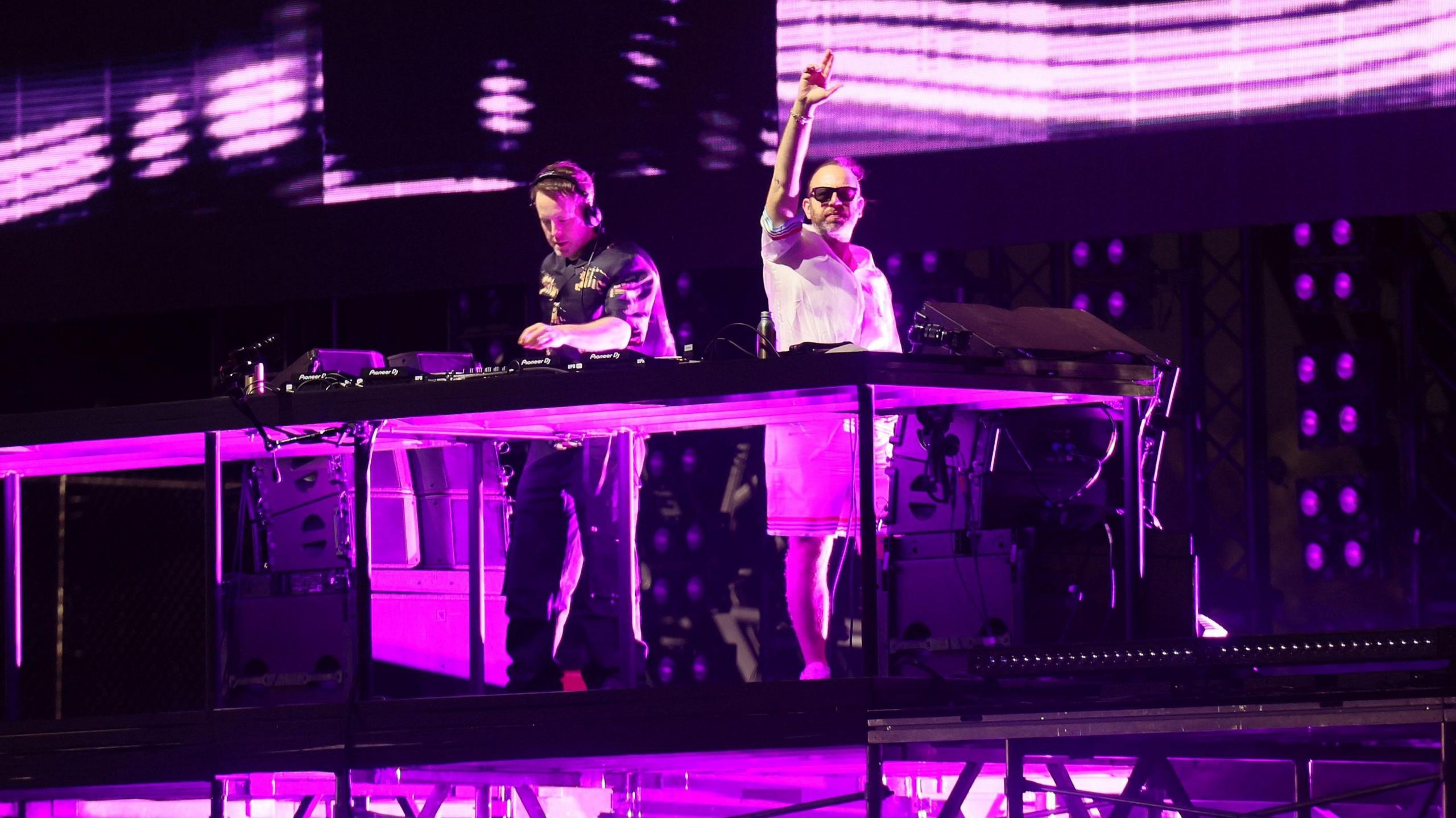 Chase & Status perform at DJ set at Coachella. There is a purple hue cast over the performers.