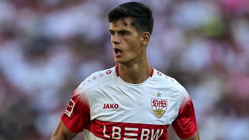 Chema Andres, in Stuttgart's red-and-white kit, looks on during a Bundesliga match with the crowd in the background