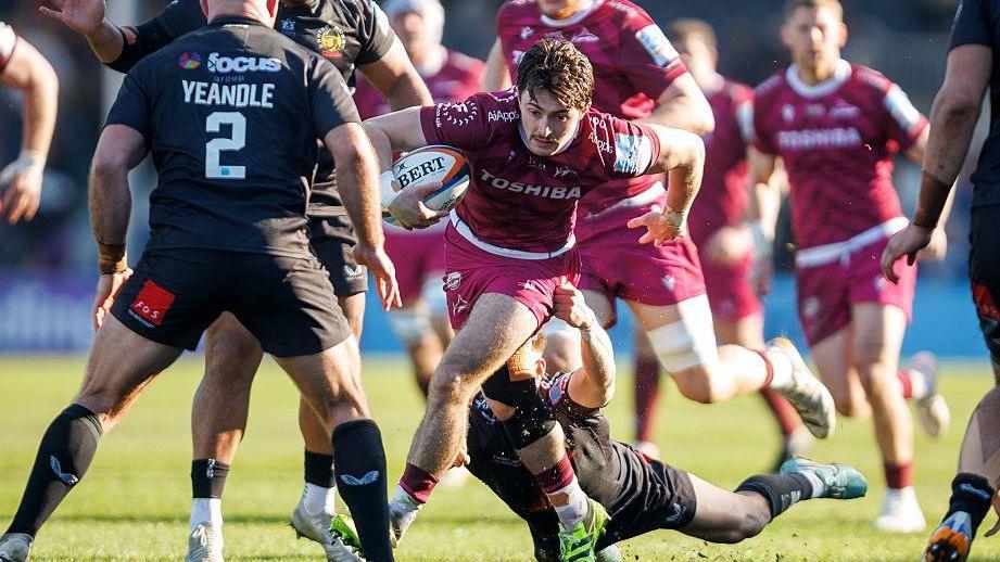 Raffi Quirke carries the ball and evades tackles as he plays rugby for Sale Sharks