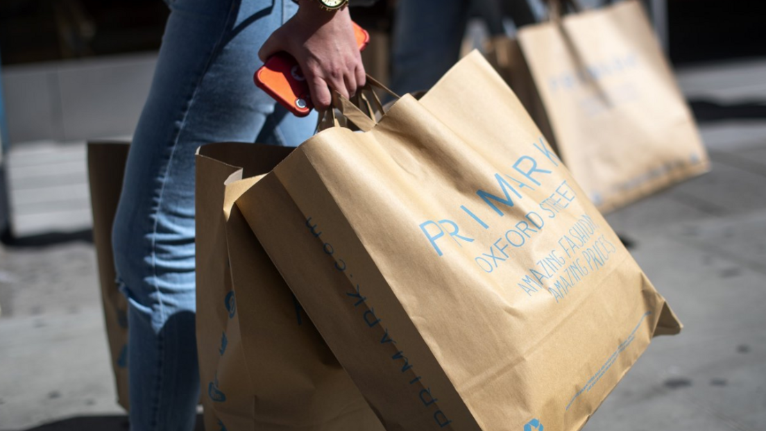 Woman carries Primark paper bags