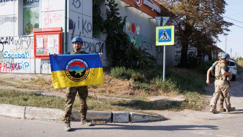 Ukrainian servicemen walk past a supermarket on September 10, 2024 in Sudzha, Kursk Region, Russia