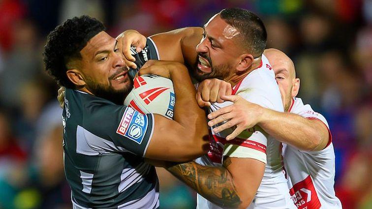 Huddersfield Giants' Taane Milne (left, in black and grey) is tackled by Hull Kingston Rovers' Elliot Minchella (right, in white and red)