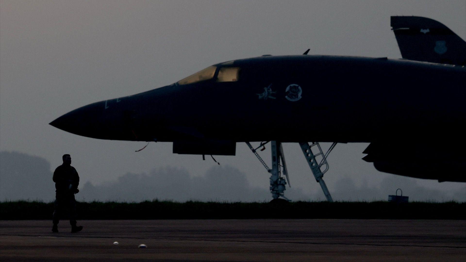 A member of ground crew works next to a B‑1B Lancer military aircraft at RAF Fairford airbase