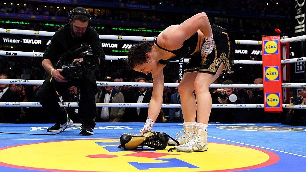 Katie Taylor lays her gloves down in the centre of the Croke Park ring