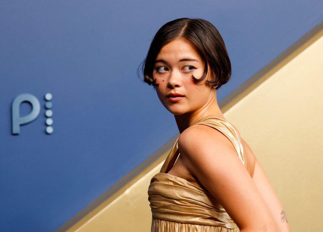 In pictures: Stars on red carpet at Emmy Awards in LA Lukita Maxwell looking behind her ina gold dress