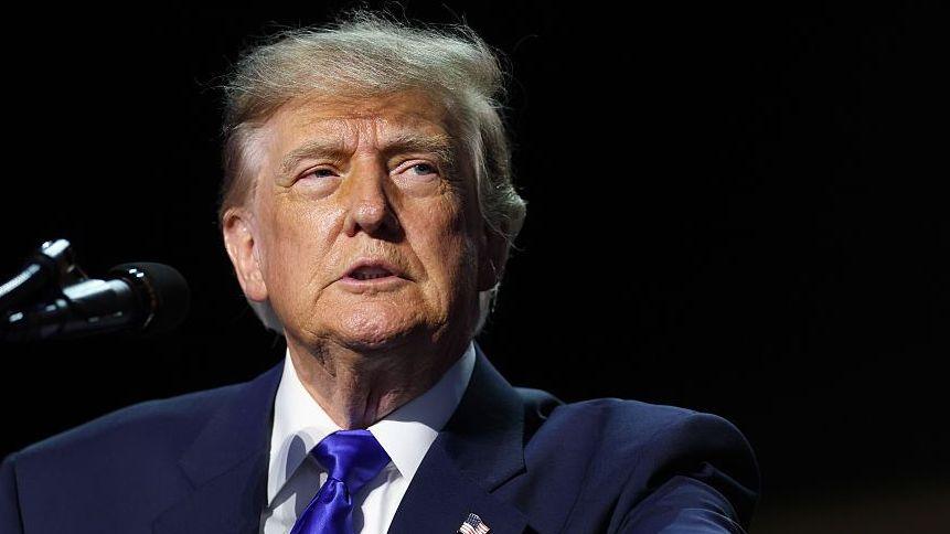 File image of US President Donald Trump speaking into a microphone