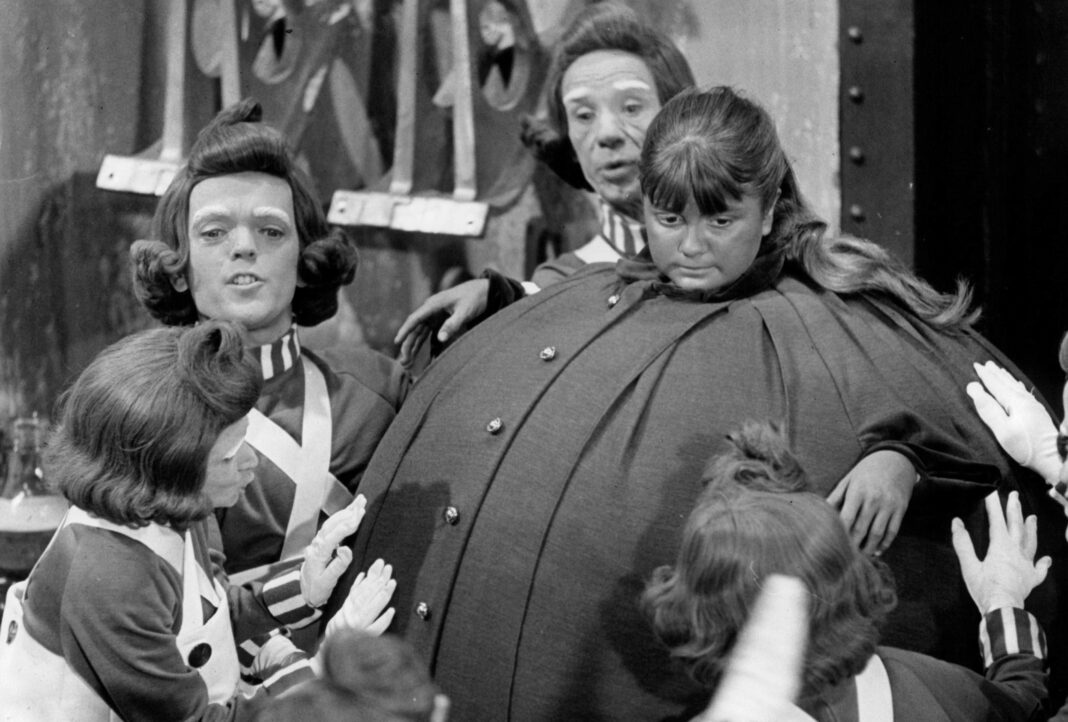 A black and white still shows a scene from the original Willy Wonka film