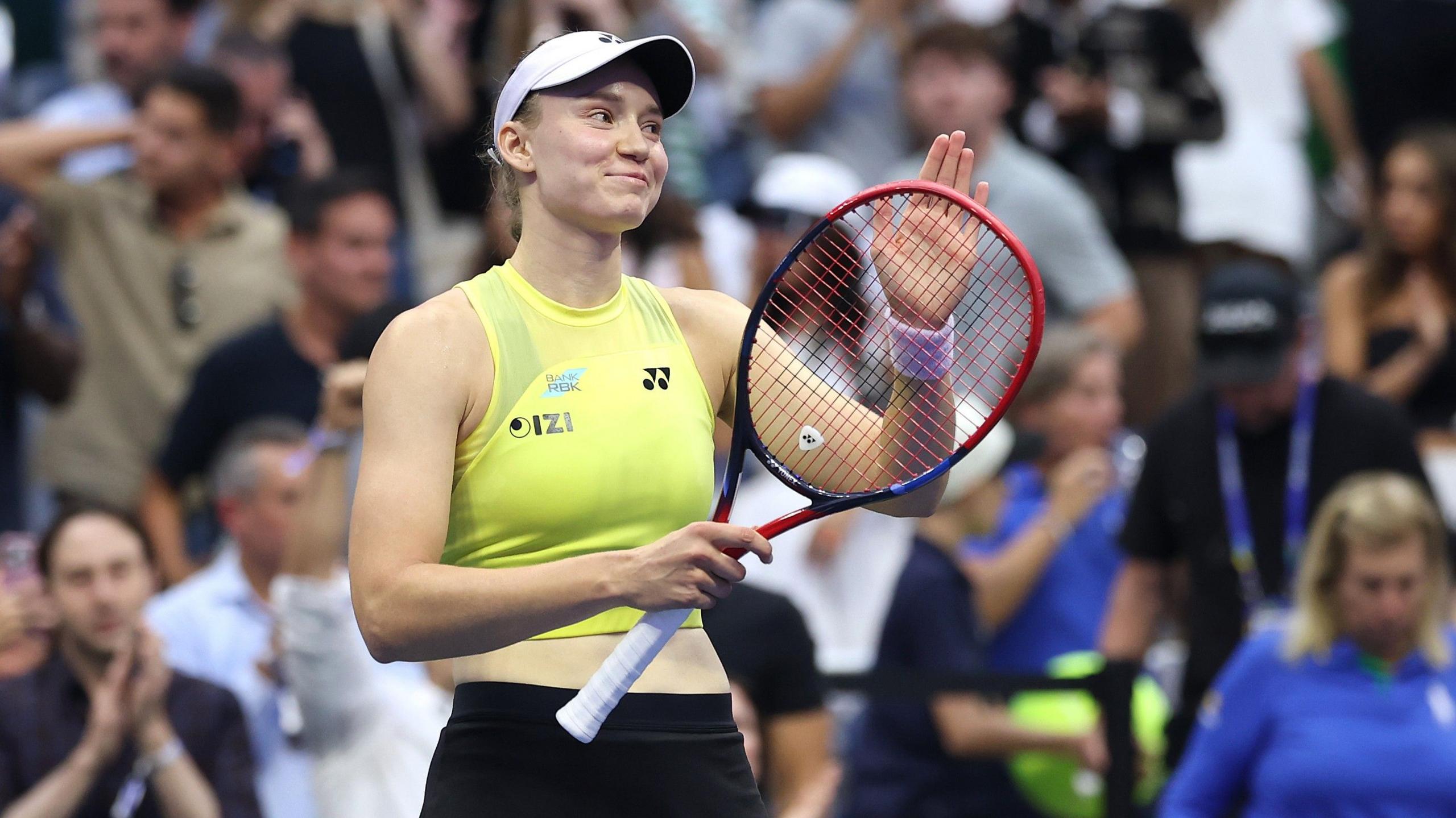 Elena Rybakina taps her racquet