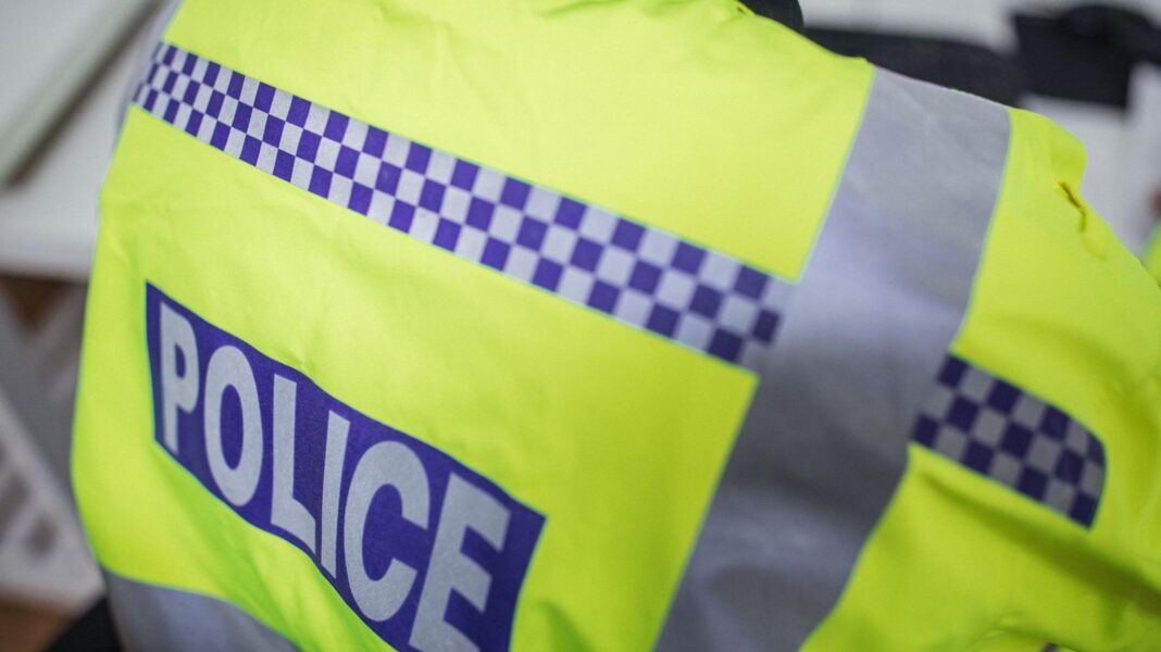 Man charged with assisting Russian intelligence service A policeman wearing a high-visibility jacket with the word police written on the back