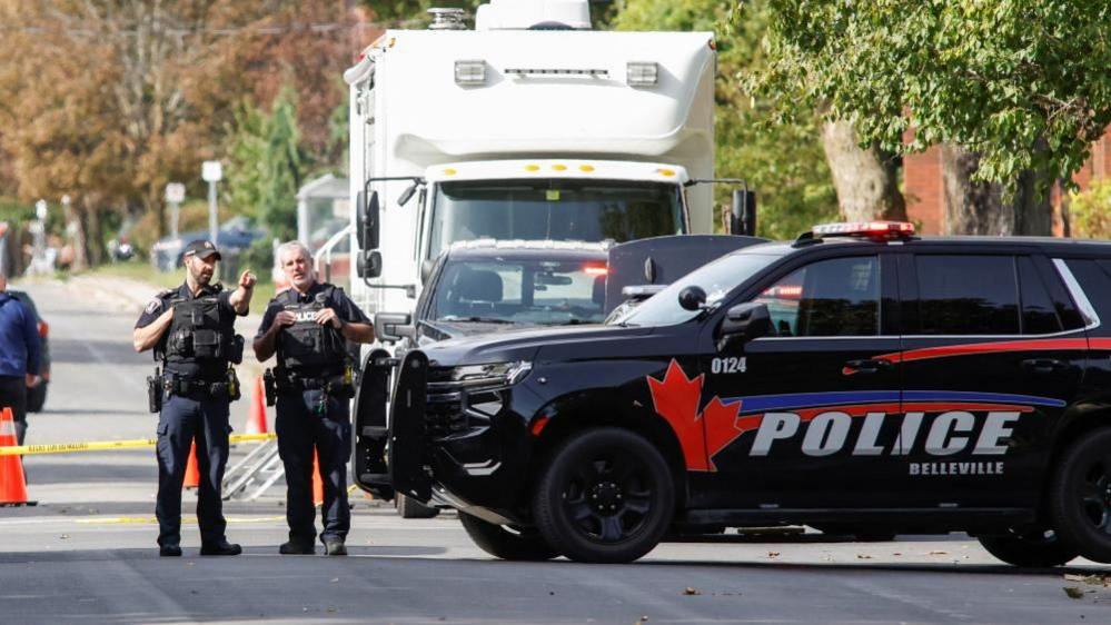 Police officers gather outside location of shooting in Belleville, Ontario